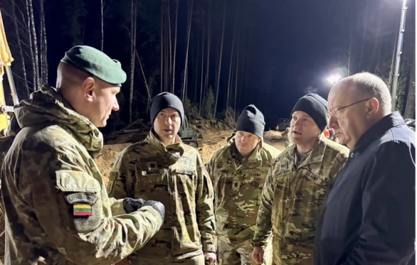 Ответственный за оборону Евросоюза - справа от своих военных.