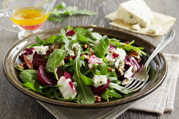 Preparing a Light Salad with Beets, Nuts, Arugula, and Goat Cheese
