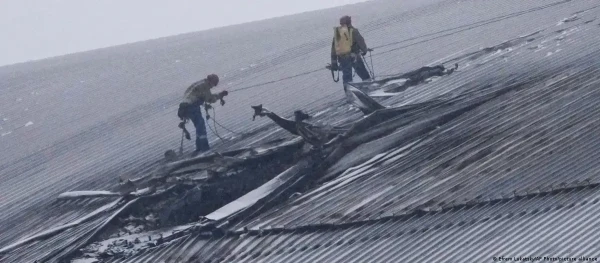 Промышленные альпинисты осматривают последствия российского удара.