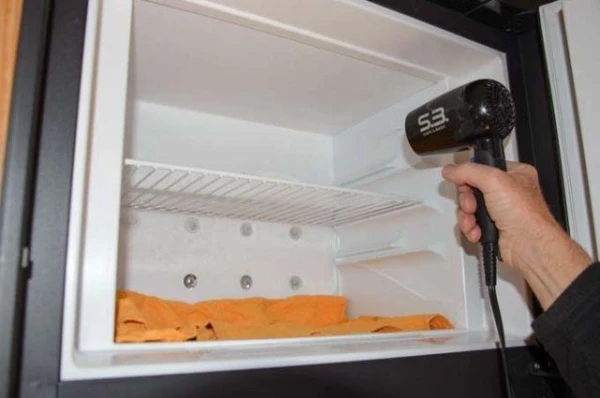 Is it possible to use a hairdryer to defrost a refrigerator?