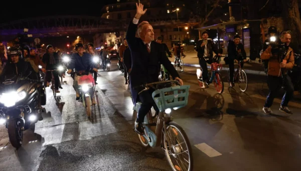 Социалист Эмманюэль Грегуар, новый мэр Парижа, направляется к зданию мэрии на прокатном велосипеде.