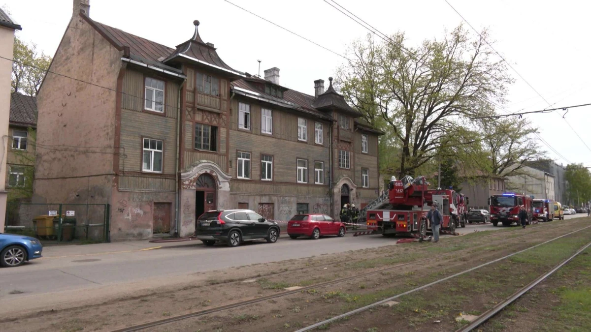 Пожарные возле старого деревянного дома в Риге, где произошел пожар повышенной опасности
